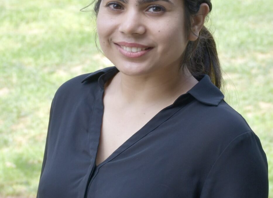Smiling person outdoors wearing black shirt.